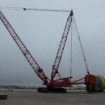 A large crane is in the middle of an empty lot.