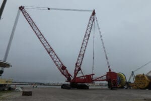 A large crane is in the middle of an empty lot.