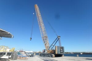 A large crane is in the middle of a dock.